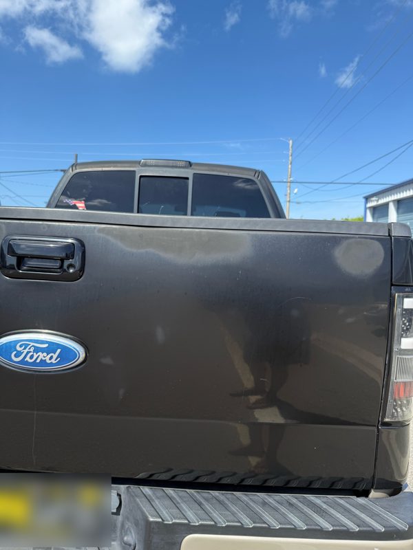 F-150 tailgate with faded, oxidized paint before correction