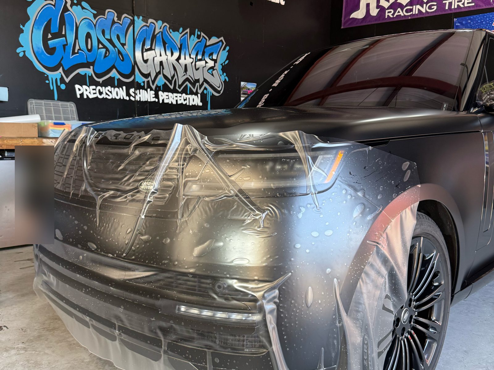 PPF being laid over the Range Rover bumper and hood in the Gloss Garage bay